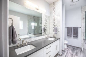 white and light grey bathroom with dark stone counter top
